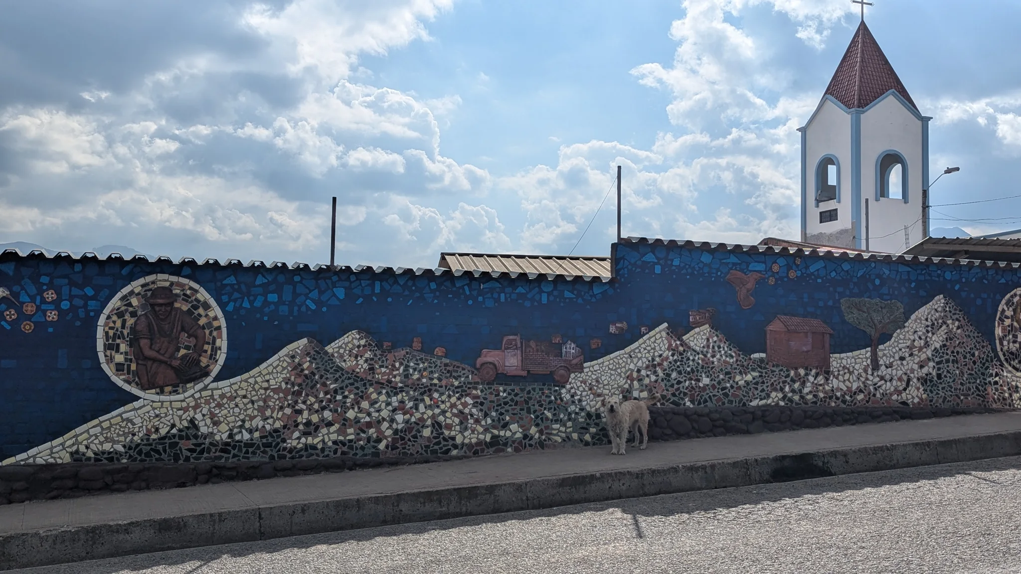 A mural with a church and decorative figures stretches along a wall.