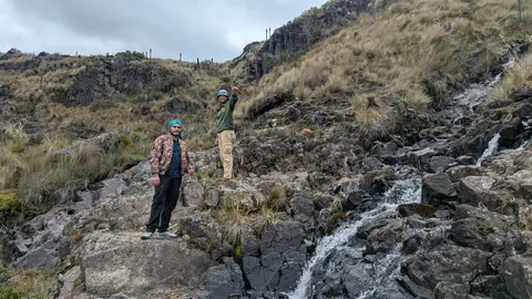 Hikers beside a rocky cascade