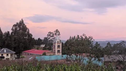 A church tower beneath soft pink clouds