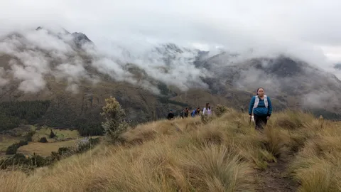 A small figure among clouds and grass