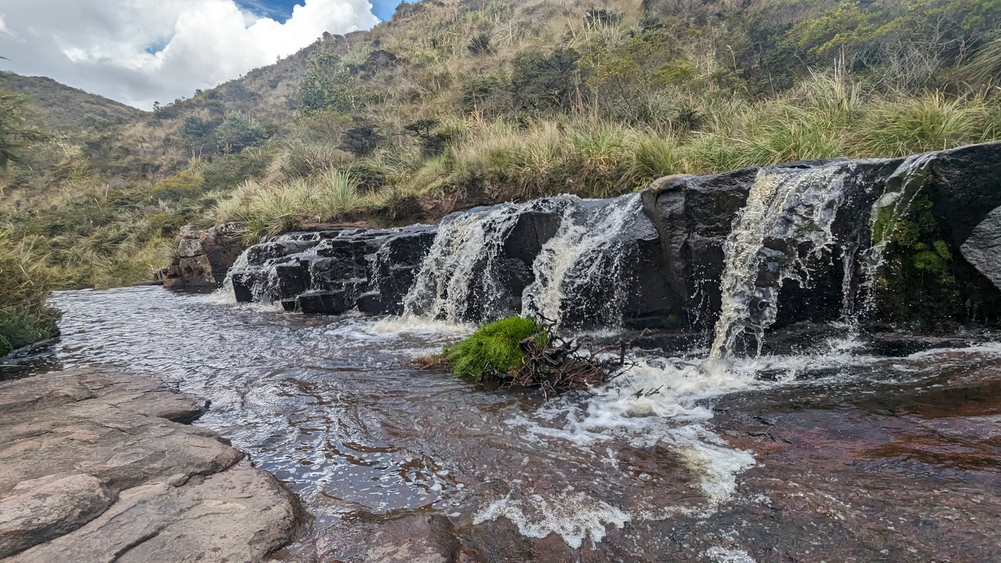 A waterfall spreads across a rock shelf
