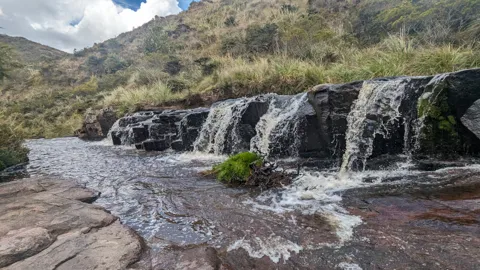 A waterfall spreads across a rock shelf