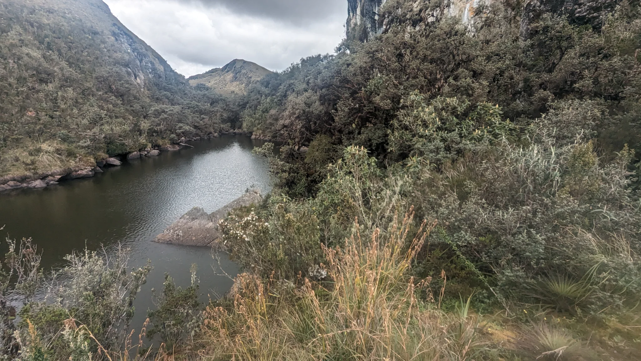Lake below scrubby highland slopes. The water body is not securely named.