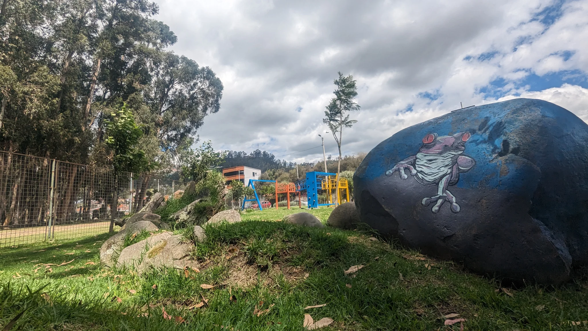 A painted boulder in a green park