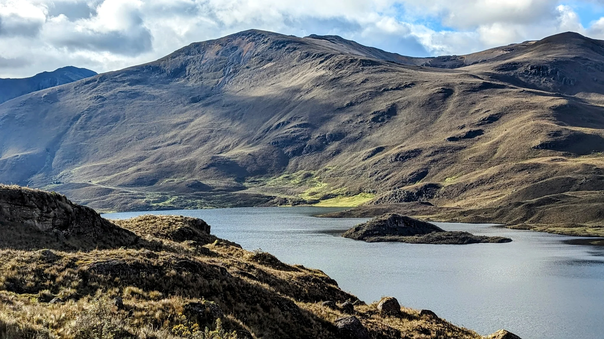 Sunlit slopes above pale water