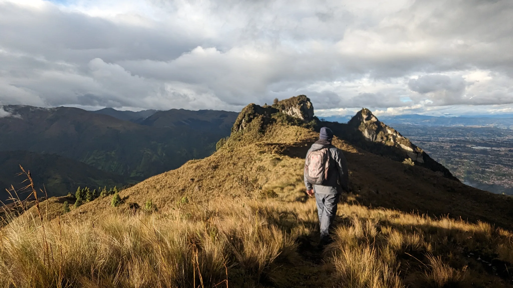 A walker on a sunlit grassy ridge
