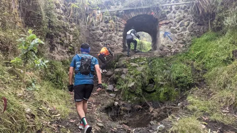 A muddy approach to a stone arch