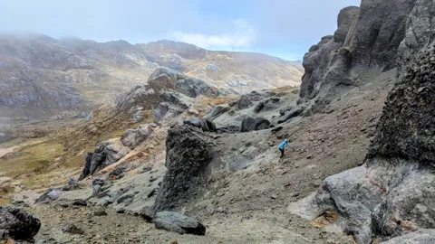 A walker beneath steep rock walls