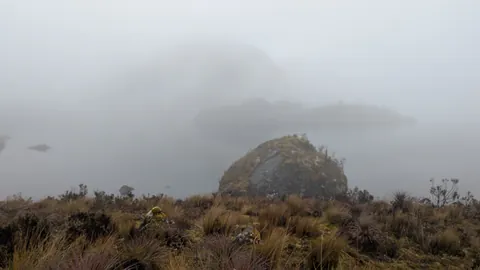 Large boulder above a fogbound lake. The water body is not securely named.