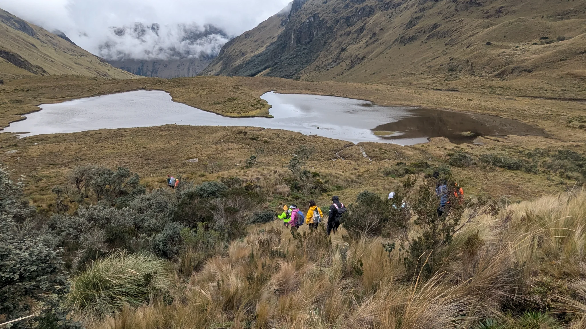 Hiking group above a broad shallow lake. The water body is not securely named.