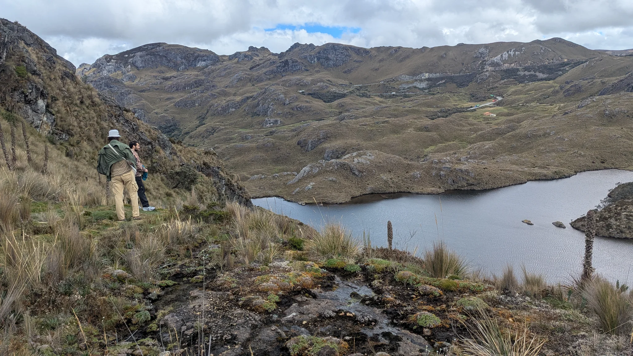 Hiker looking across a rocky lake basin. The water body is not securely named.