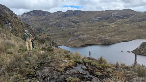 Hiker looking across a rocky lake basin. The water body is not securely named.