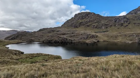 A round lagoon below a rocky summit
