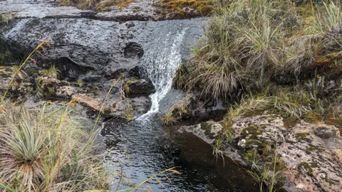 Water flowing between mountain rocks