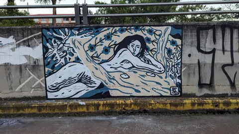 A blue fish mural beneath a railing