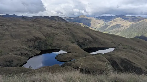 Two dark lakes below high ridges. The water body is not securely named.