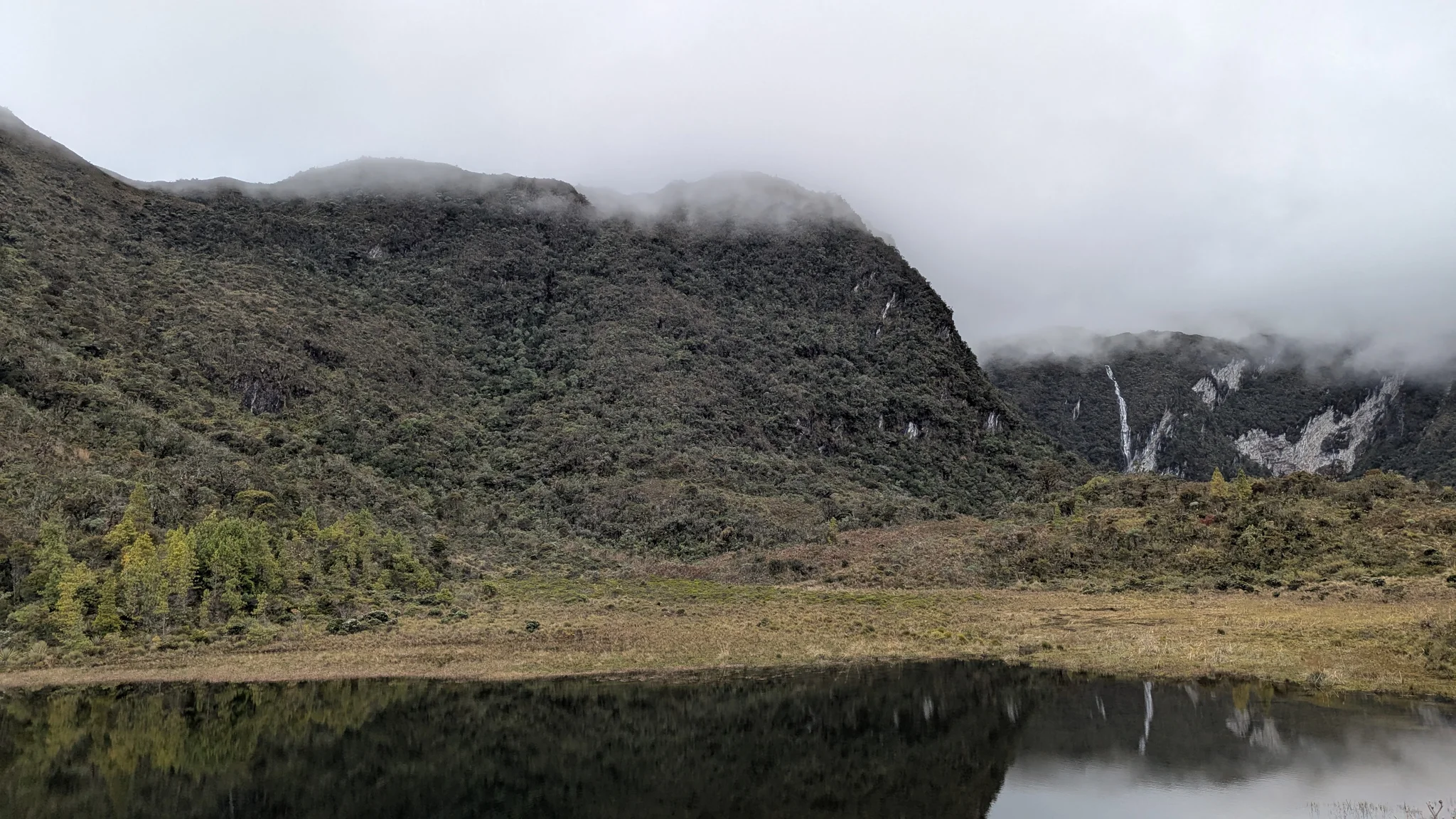 Misty lagoon below dark ridge. The water body is not securely named.