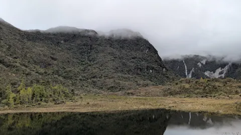 Misty lagoon below dark ridge. The water body is not securely named.