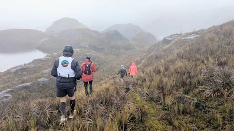 Hooded hikers above a misty lake. The water body is not securely named.