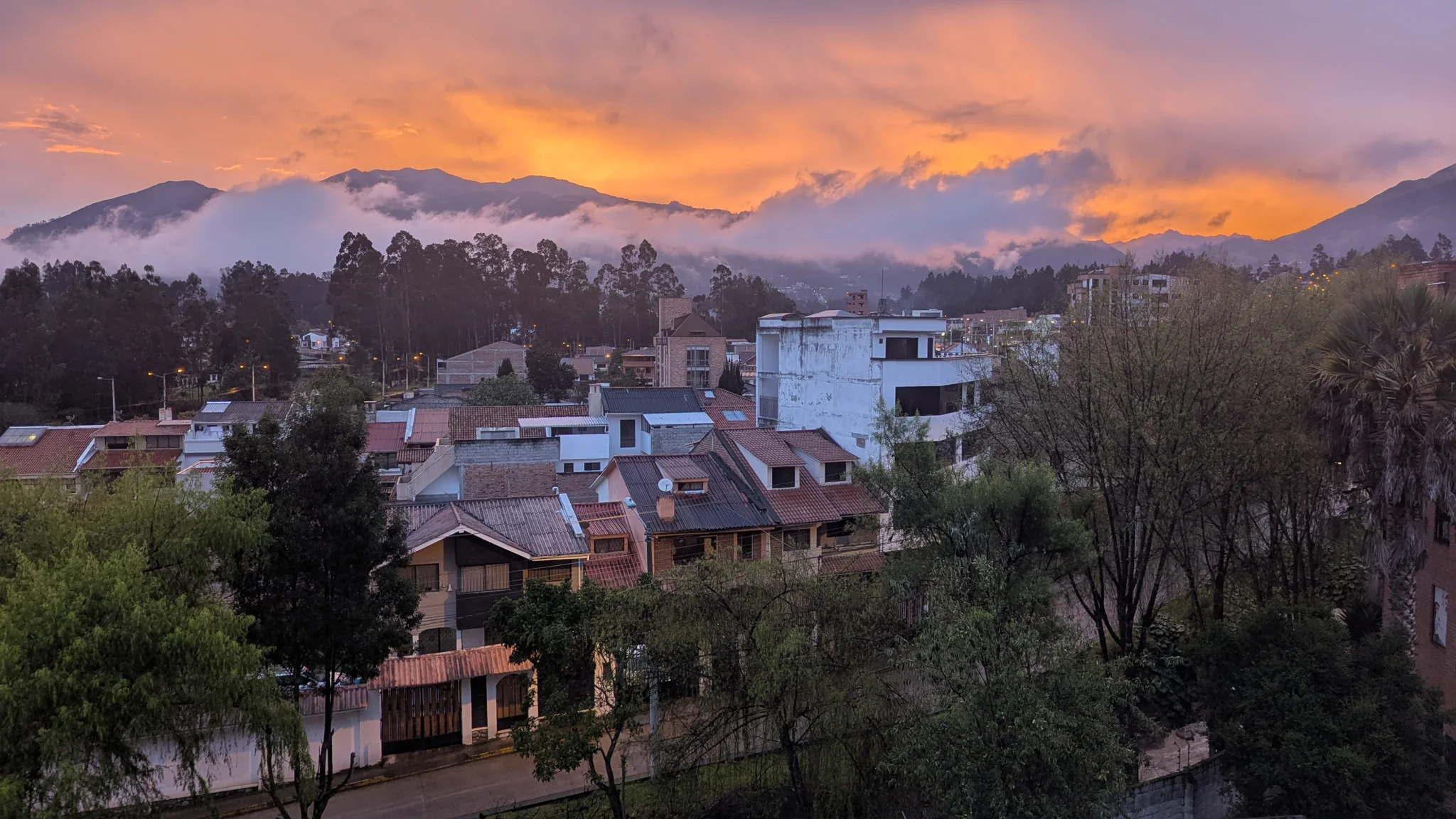 Orange light above hillside homes
