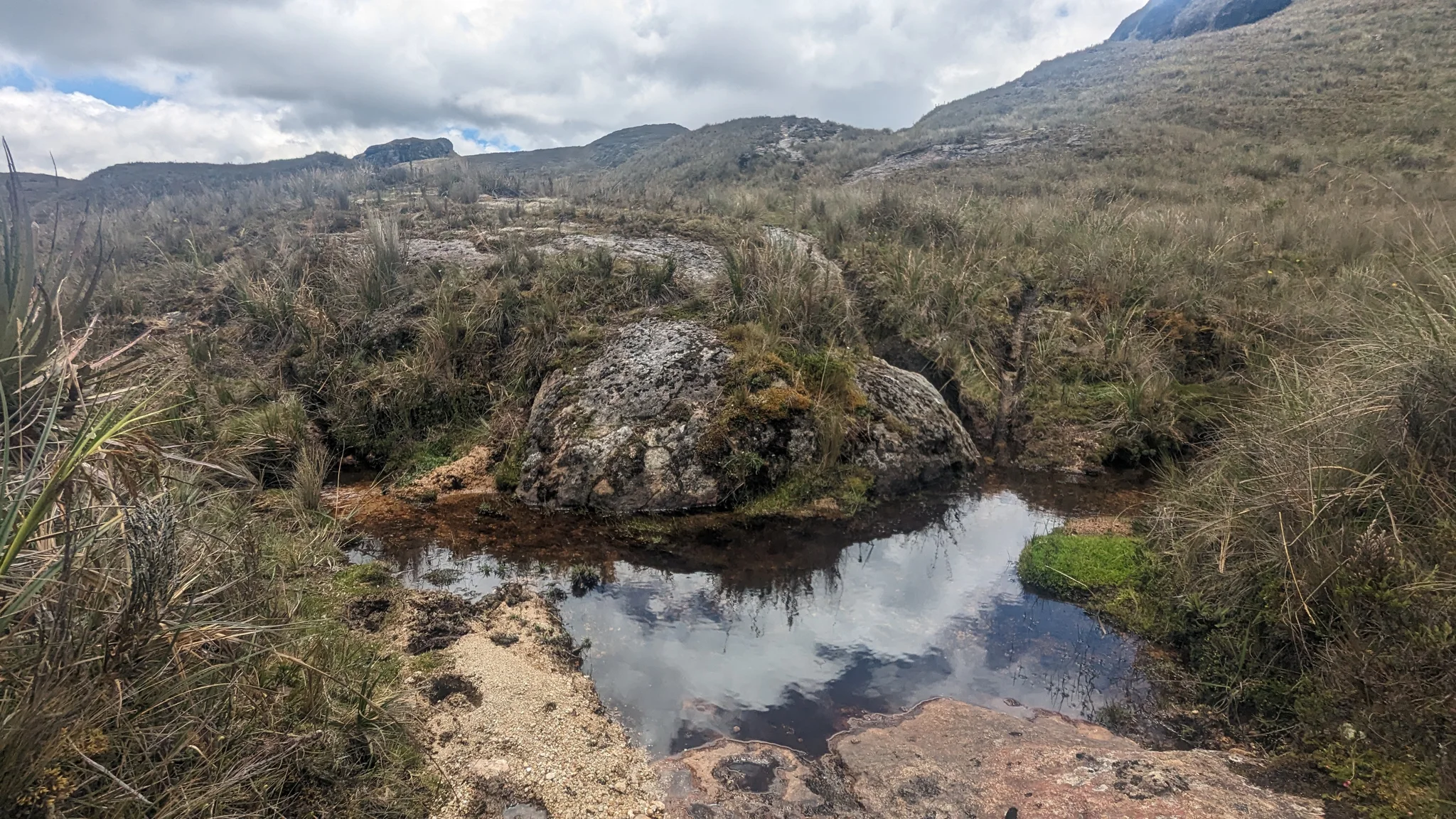 Small highland pond below rocky slopes. The water body is not securely named.